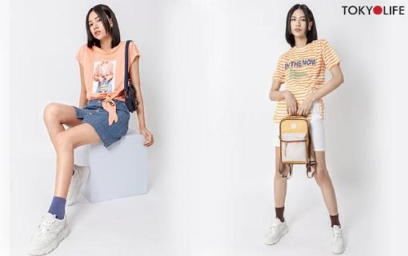 Một cô gái trẻ năng động phối chân váy xòe đen dài với áo thun basic và giày thể thao, phong cách hàng ngày.